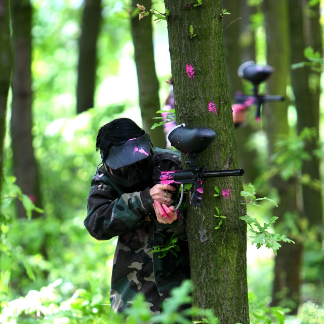Pegado detrás de un árbol